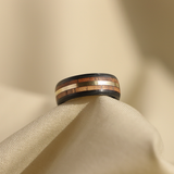 hawaiian koa wood ring with a gold inlay and carbon fiber sleeve on cloth