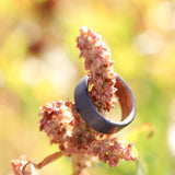 Whiskey Barrel Wedding Ring with Carbon Fiber Exterior on a pretty flower