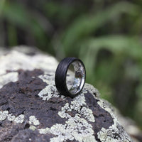 Men's Titanium Wedding Band with Carbon Fiber On A Rock In The Forest