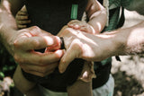 A men's koa wood wedding ring on a hand