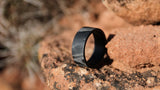 men's carbon fiber wedding ring on the red rocks of the desert 