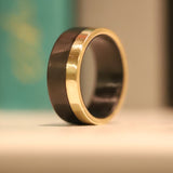 Men's carbon fiber ring with yellow gold band close up