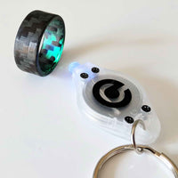 A micro uv key chain light shining on a carbon fiber glow ring