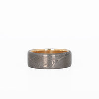 damascus wedding ring with gold sleeve laying flat