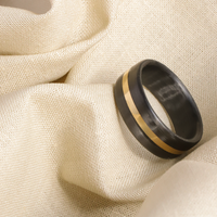 carbon fiber men's wedding ring with yellow gold band on cloth