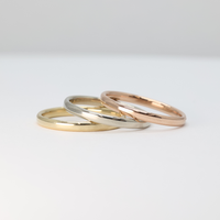 gold stackable rings set with rose gold, white gold, and yellow gold laying flat