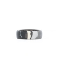 black camo wedding ring with carbon fiber sleeve laying flat