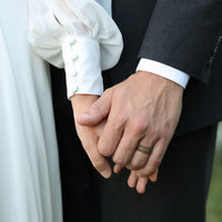 Turquoise Inlay Ring with Whiskey Barrel Wood and Carbon Fiber Sleeve Worn On A Groom's Hand At A Wedding